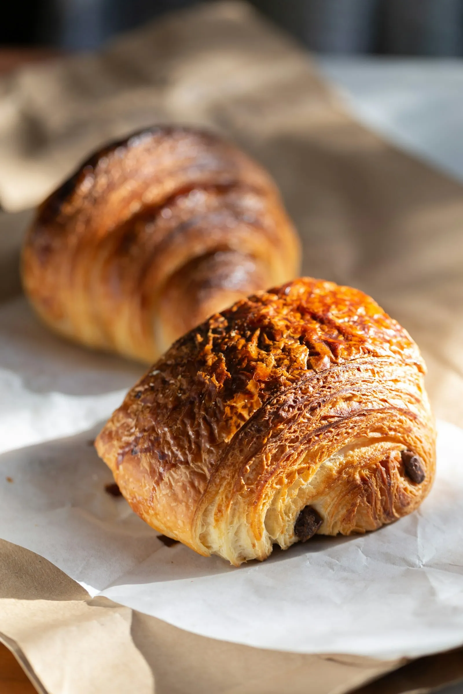 A pain au chocolat and a croissant on paper