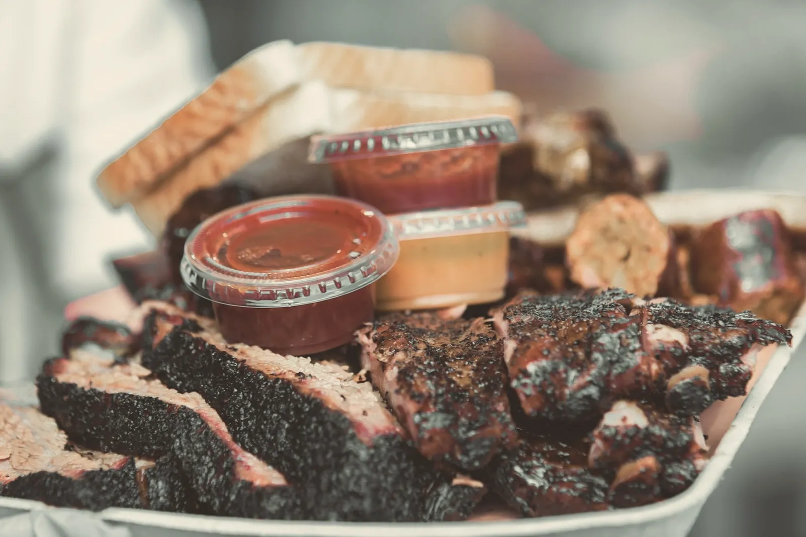 A combination plate of brisket and ribs with sauces