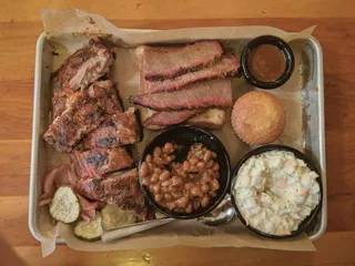 A barbecue tray with two meats and sides