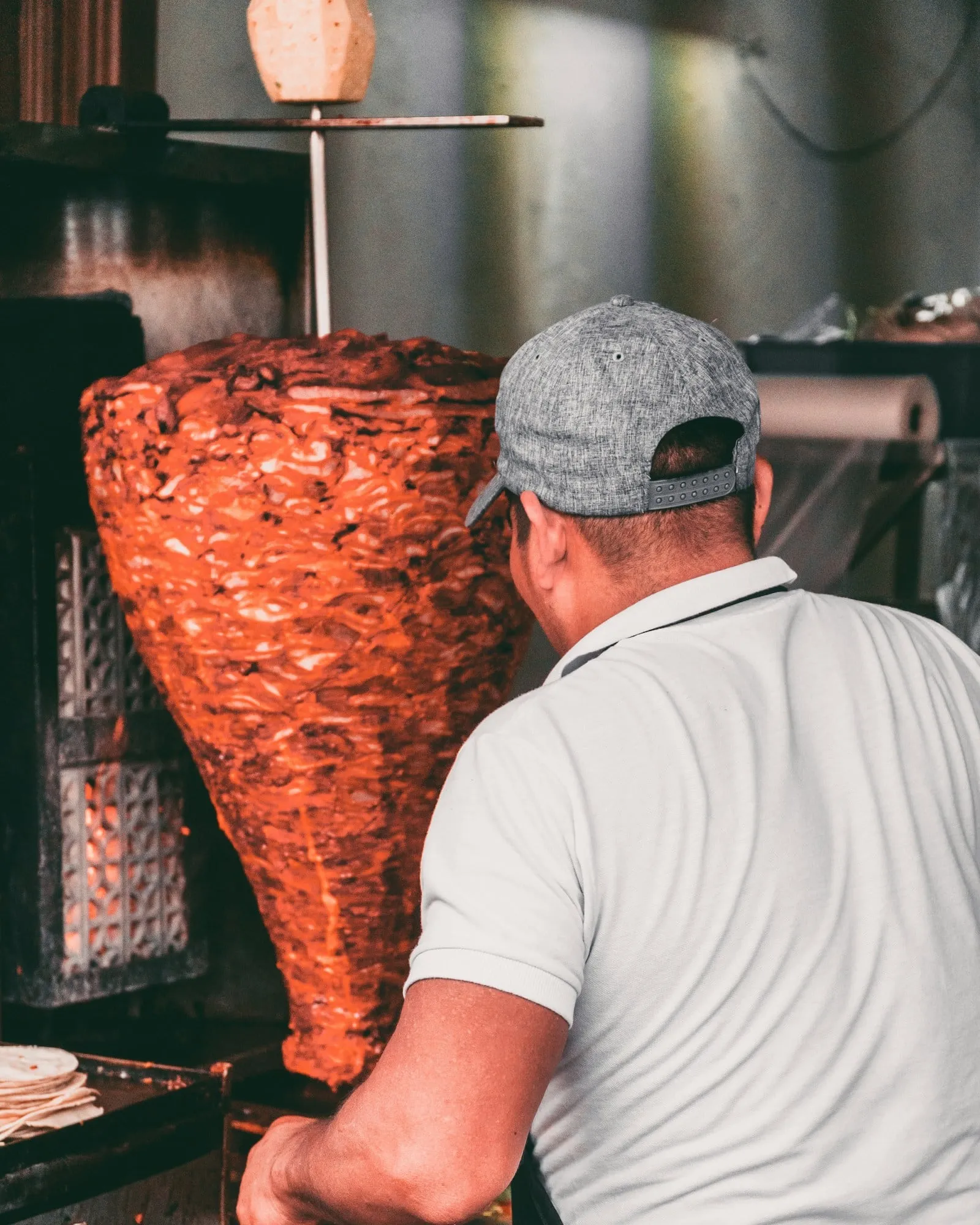 A taquero carving al pastor from the trompo