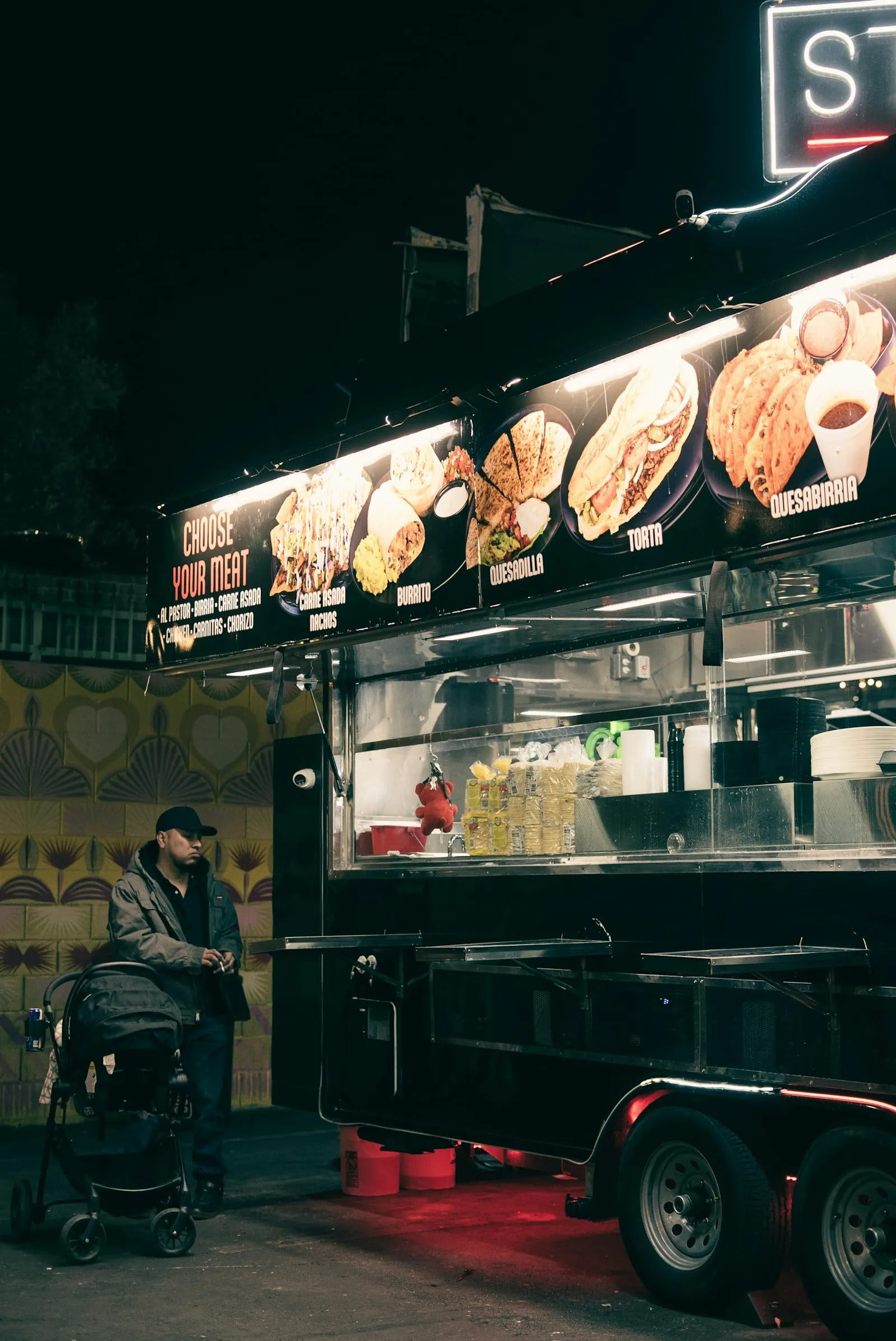A brightly lit food truck window at night